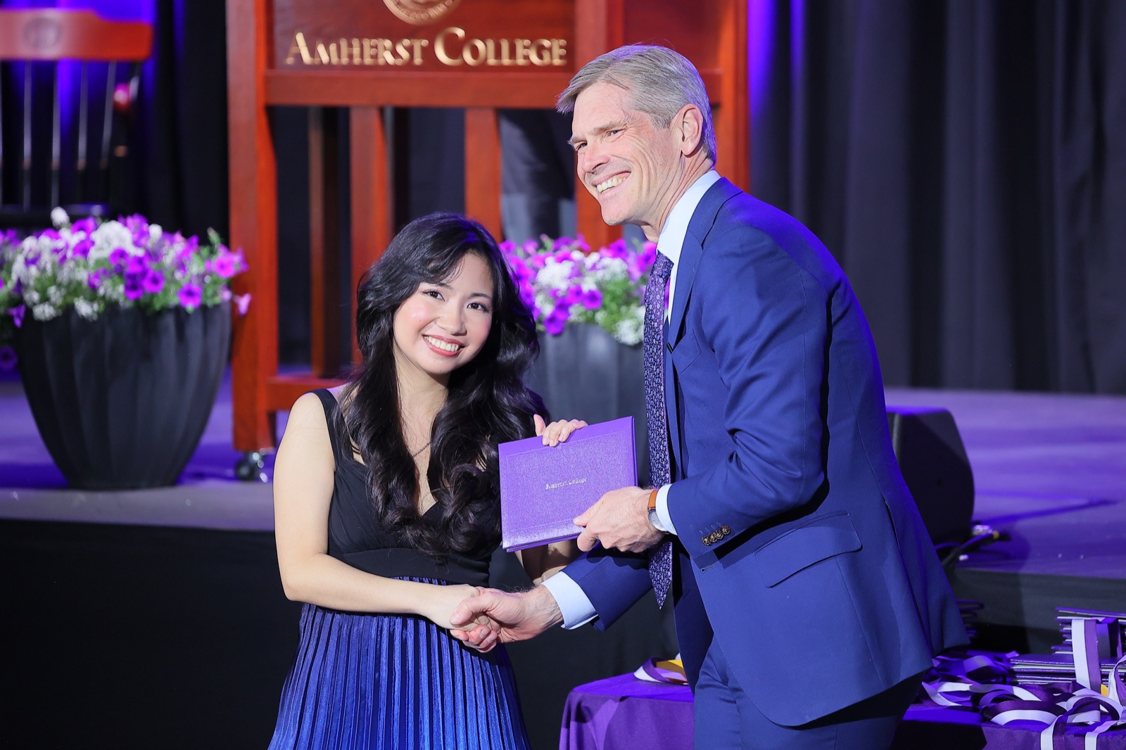 Erika Salvador receiving a certificate onstage at Amherst College